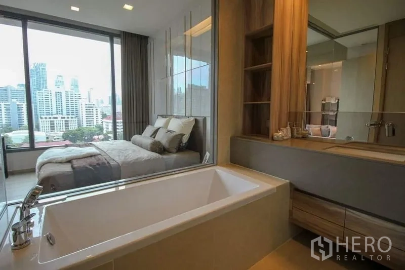 公寓 出售在Watthana, Bangkok - 套内浴室设浸泡浴缸，玻璃窗望向卧室与曼谷城景。