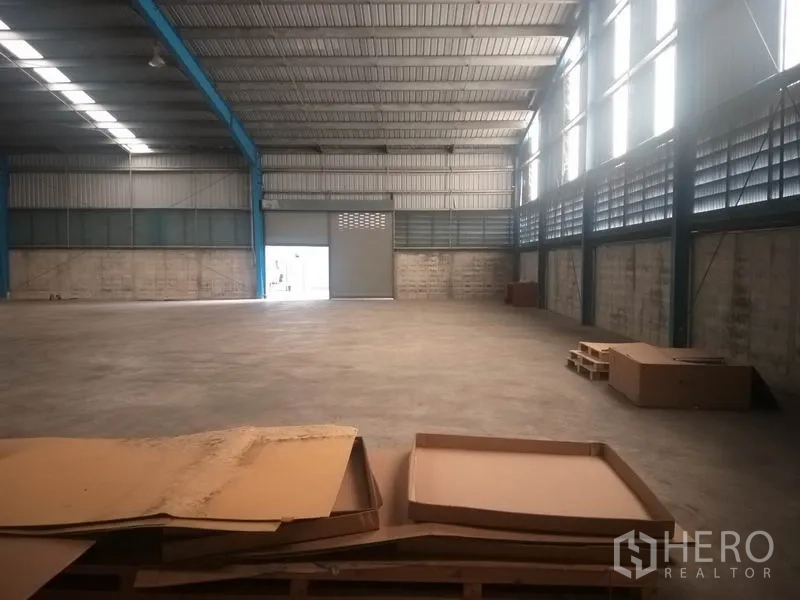 货栈 出租在Pathum Thani - 室内角度，见卷闸门与平整混凝土地面