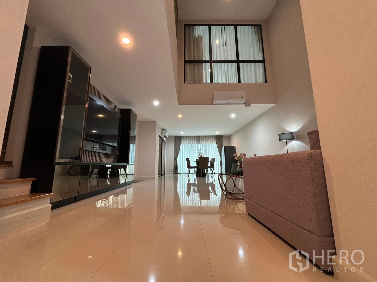 Townhouse for rent in Saphan Sung, Bangkok - Ground-floor view of open-plan living and dining with glossy tile floors.