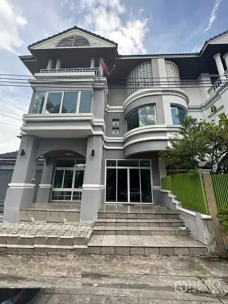 联排别墅 出租在Bang Kapi, Bangkok - 三层灰色联排别墅外立面，带弧形飘窗、阳台和宽台阶，蓝天映衬。