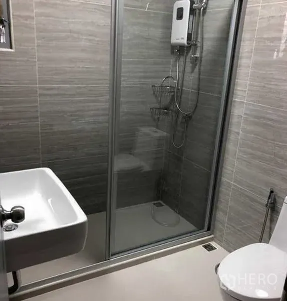 Detached House for rent in Phra Khanong, Bangkok - Modern bathroom with glass‑enclosed shower, wall tiles, sink and toilet.