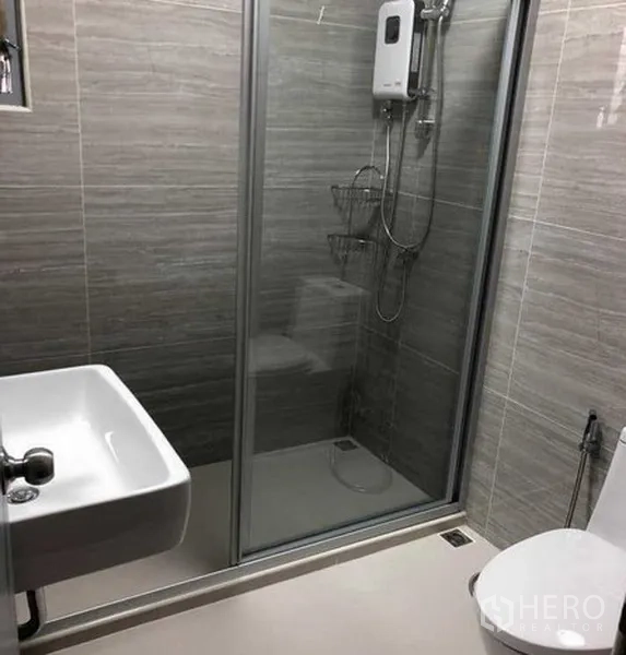 Detached House for rent in Phra Khanong, Bangkok - Modern bathroom with glass‑enclosed shower, wall tiles, sink and toilet.