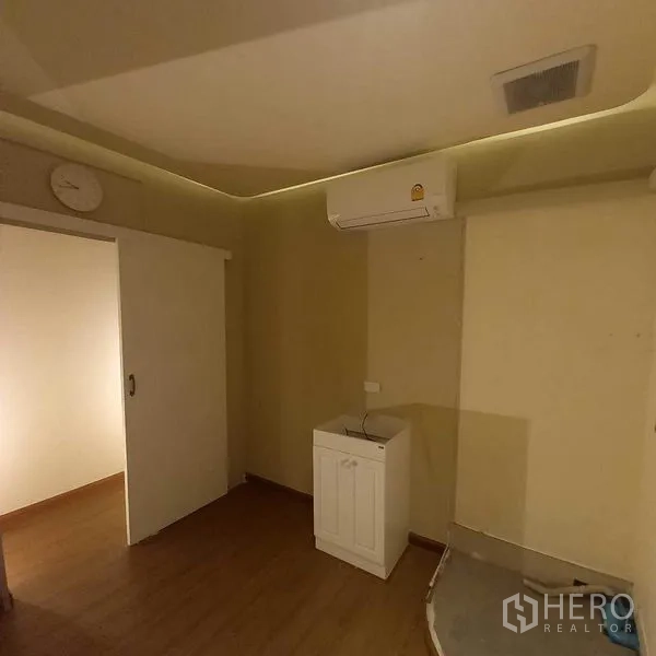 Shophouse for rent in Watthana, Bangkok - Compact room with sliding door, ceiling AC and a vanity sink