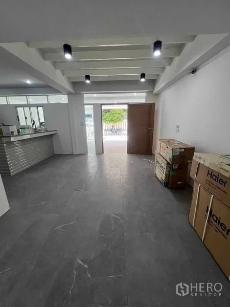 联排别墅 出租在Khlong Toei, Bangkok - 一层开放式起居区，深色地砖，旁接厨房。