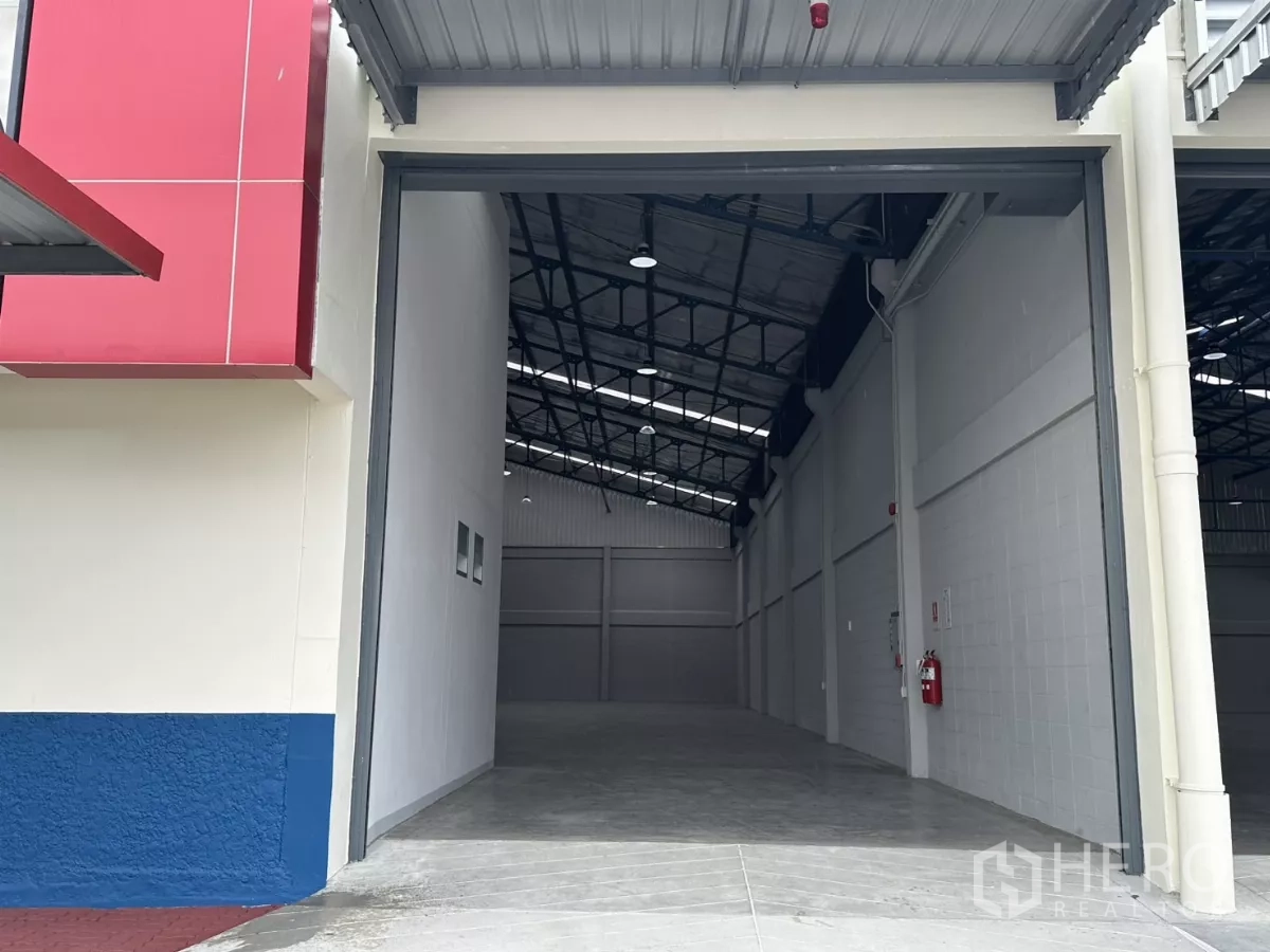 Factory for rent in Bang Phli, Samut Prakan - Wide roller shutter loading entrance opening to the warehouse interior.