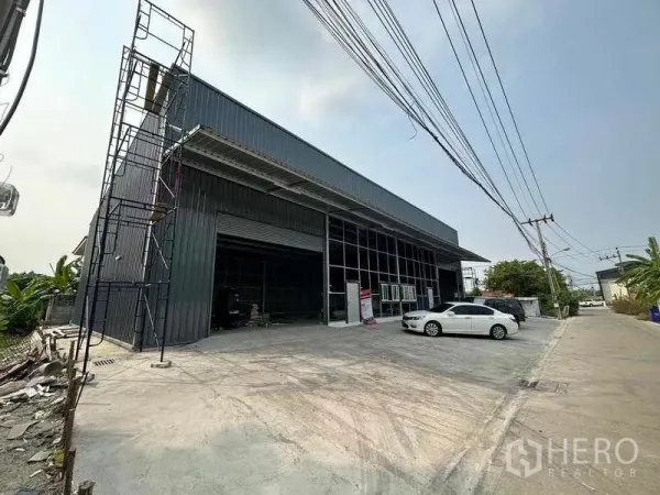 货栈 出租在Pak Kret, Nonthaburi - 仓库外立面斜角视图，装卸区、高挑雨棚与宽阔车道，便于货车出入。