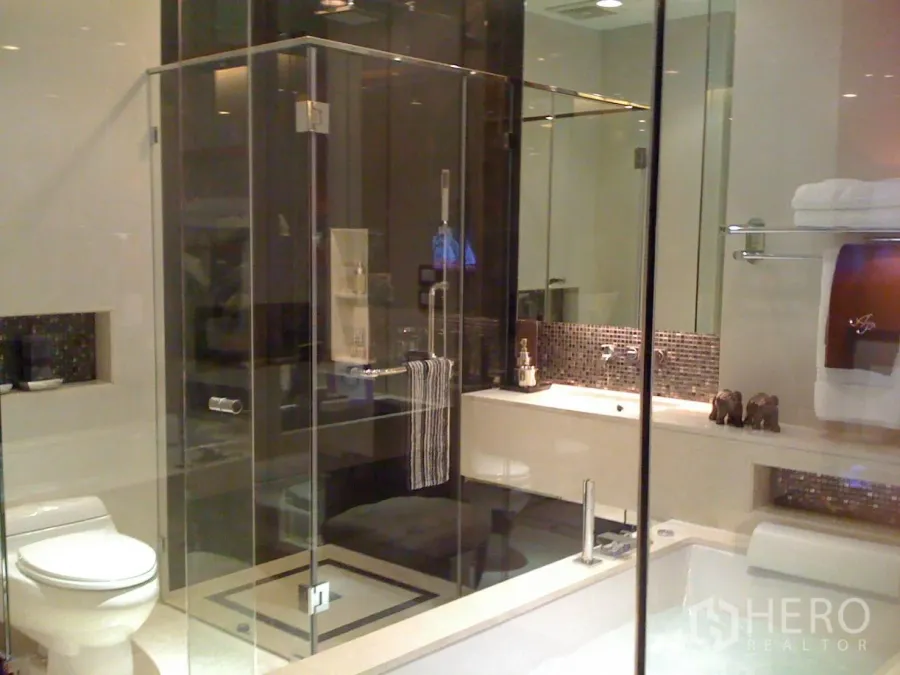 Condominium for rent or sale in Khlong Toei, Bangkok - Modern bathroom with glass-enclosed shower, soaking tub, and mosaic backsplash in a Bangkok condo.