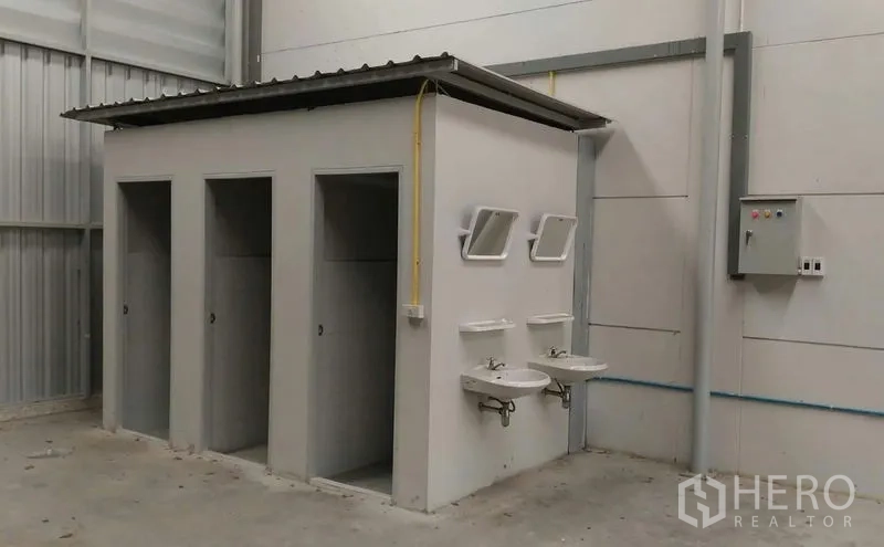 Warehouse for rent in Pathum Thani - Onsite restroom block with sinks and mirrors inside the warehouse.