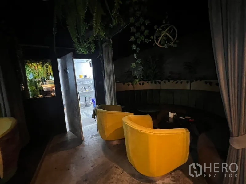 พื้นที่ขายปลีก ให้เช่าในWatthana, Bangkok - ห้องเลานจ์บรรยากาศมืดพร้อมเก้าอี้สีเหลือง โต๊ะกลม และผ้าม่านกั้น
