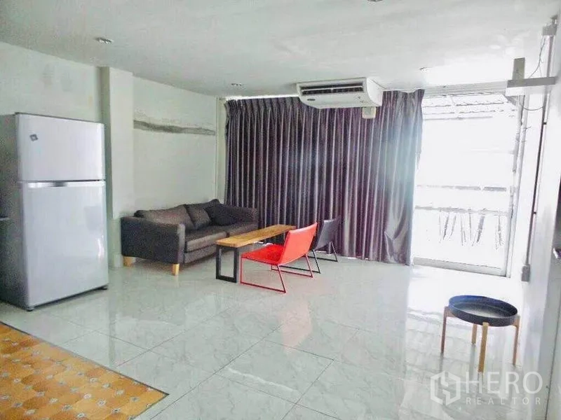 Home Office for rent or sale in Din Daeng, Bangkok - Living lounge with sofa, coffee table, fridge and balcony door with blackout curtains.
