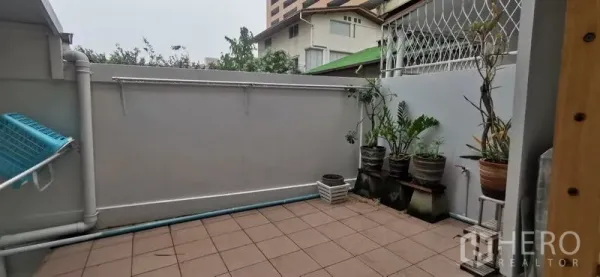 联排别墅 出租在Watthana, Bangkok - 私家庭院式瓷砖露台，摆放盆栽并设有杂务区