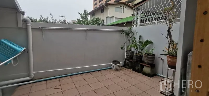 联排别墅 出租在Watthana, Bangkok - 私家庭院式瓷砖露台，摆放盆栽并设有杂务区