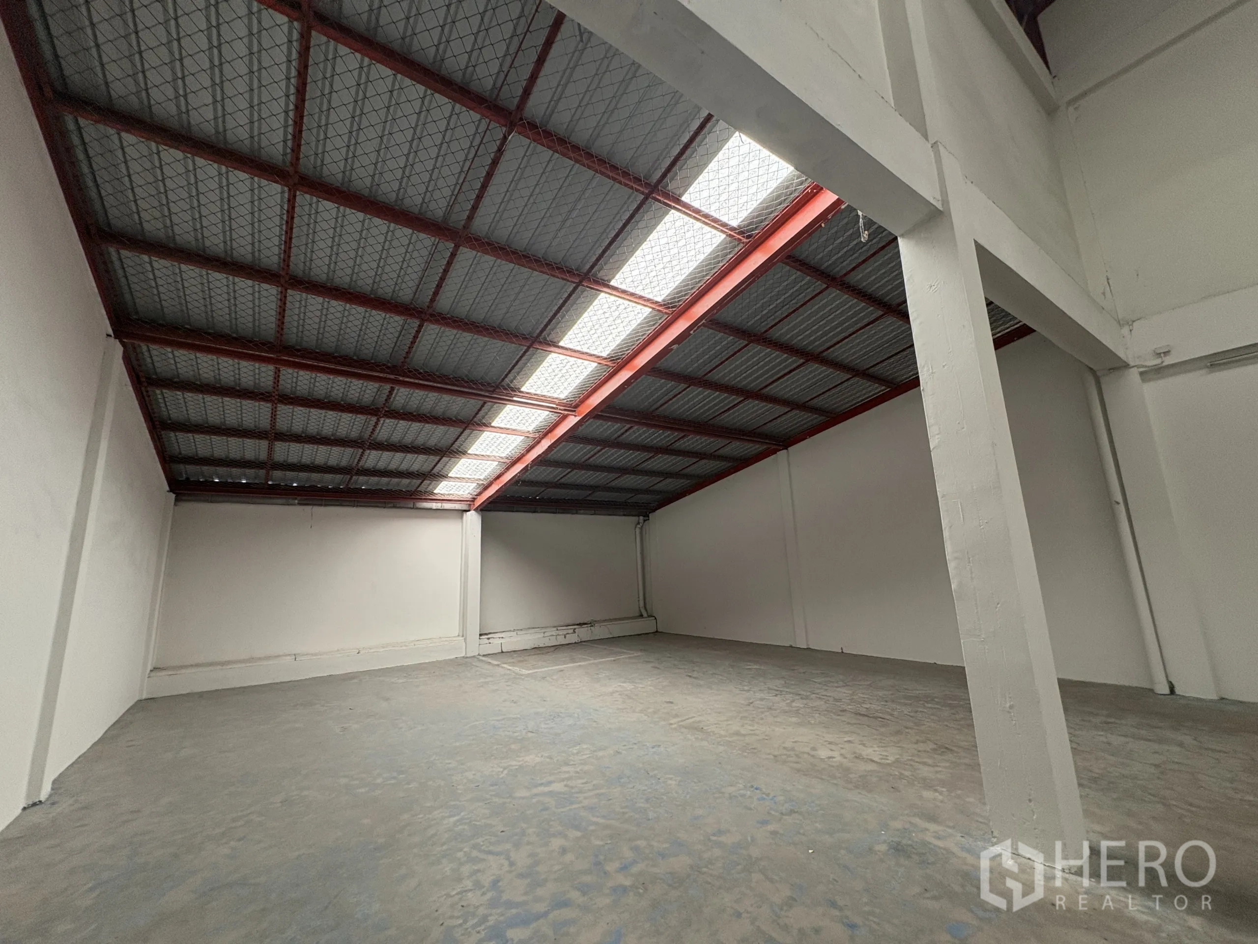 Factory for rent in Phra Samut Chedi, Samut Prakan - Mezzanine storage area beneath metal sheet roof with daylight panel.