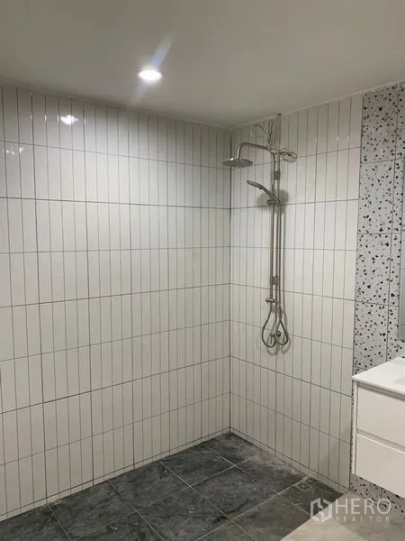 Townhouse for sale in Yan Nawa, Bangkok - Walk-in shower with vertical white tiles and rain shower fitting.