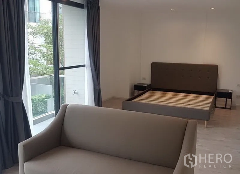 บ้าน ให้เช่าในPrawet, Bangkok - ห้องนอนมาสเตอร์ หน้าต่างบานใหญ่ ทางออกสู่ระเบียง เตียงบุนวม และพื้นที่นั่งเล่น.
