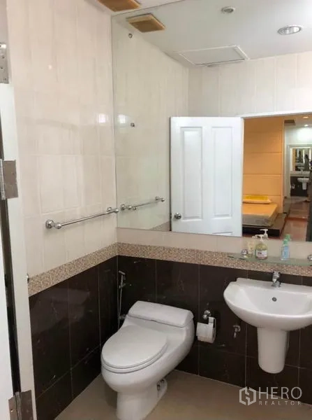 Townhouse for rent in Chatuchak, Bangkok - Tiled bathroom with large mirror, toilet and pedestal sink.