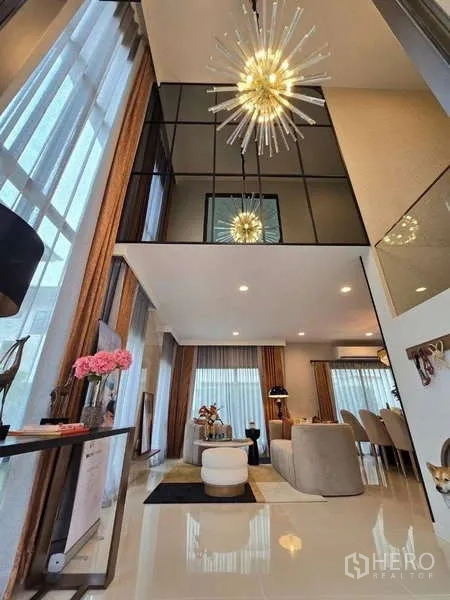 บ้าน ให้เช่าในBang Kapi, Bangkok - ห้องนั่งเล่นเพดานสูงสองชั้น โคมไฟหรู และหน้าต่างสูงจรดเพดาน