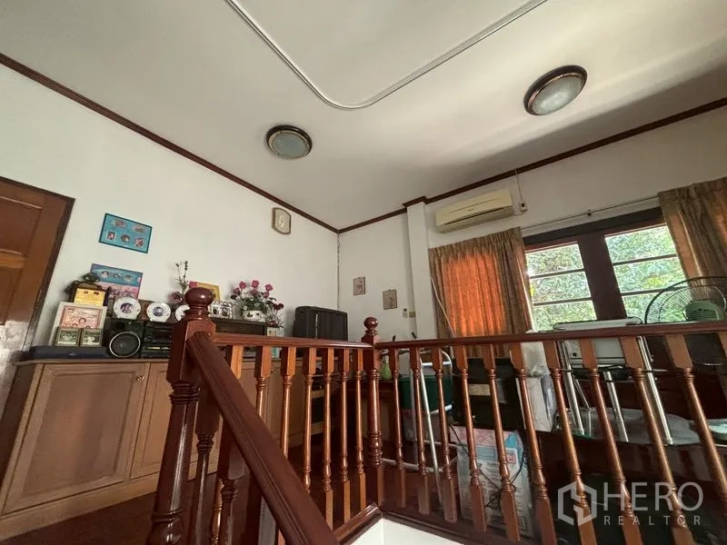 บ้านเดี่ยว for sale in Suan Luang, Bangkok - มุมชั้นบนพร้อมราวบันไดไม้ ตู้เก็บของ และเครื่องปรับอากาศ