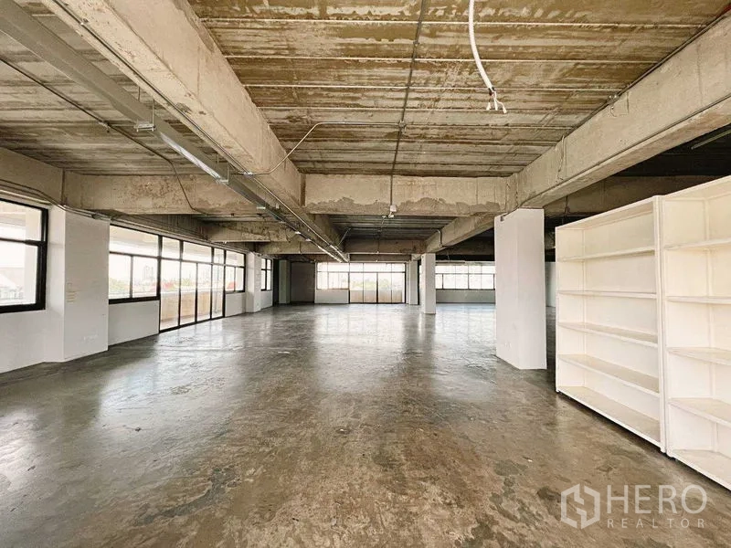 Retail Space for rent in Yan Nawa, Bangkok - Open retail area with white shelving and windows on two sides.