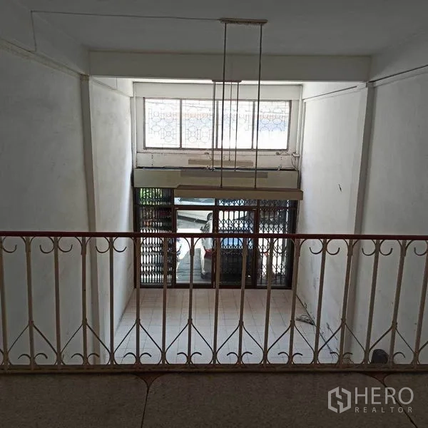 Shophouse for rent in Khlong Toei, Bangkok - Mezzanine view over the ground-floor shopfront with security gate and display window.