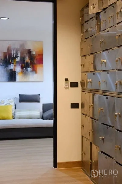 Condominium for rent in Bang Rak, Bangkok - Entry hallway with built-in metal storage lockers beside the living area.