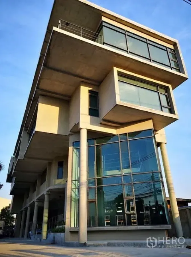 带办公室的家 出租或出售在Prawet, Bangkok - 普拉特区现代多层家居办公楼，悬挑混凝土体量与落地玻璃外立面。