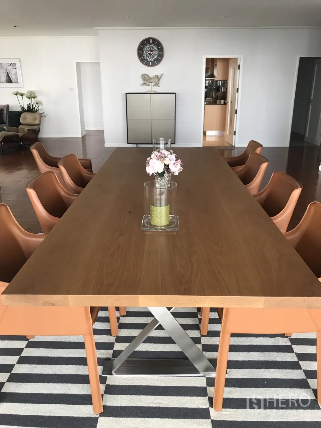 Condominium for rent in Bangkok - Close-up of modern wooden dining table and chairs on a striped rug.
