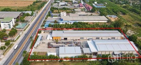 Factory for sale in Lat Lum Kaeo, Pathum Thani - Aerial view of a gated factory compound with multiple steel‑roof warehouses, wide concrete yard, and road frontage.
