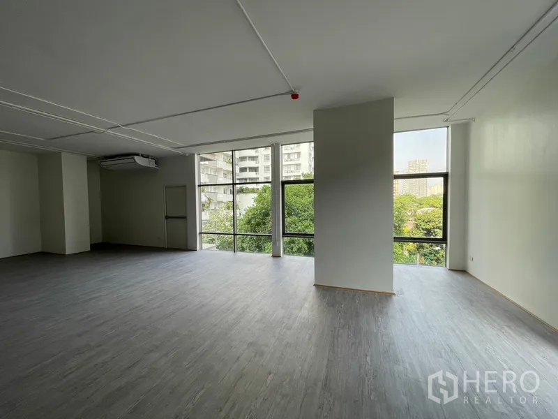 办公空间 出租在Bang Rak, Bangkok - 转角工作区，立柱与全景窗带来充足自然光。