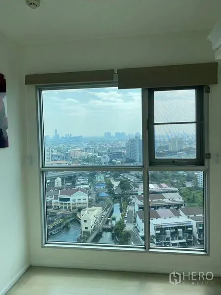 Condominium for sale in Khlong Toei, Bangkok - Large window framing high-floor skyline and canal views over Phra Khanong.
