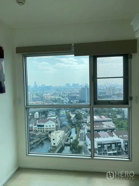 Condominium for sale in Khlong Toei, Bangkok - Large window framing high-floor skyline and canal views over Phra Khanong.