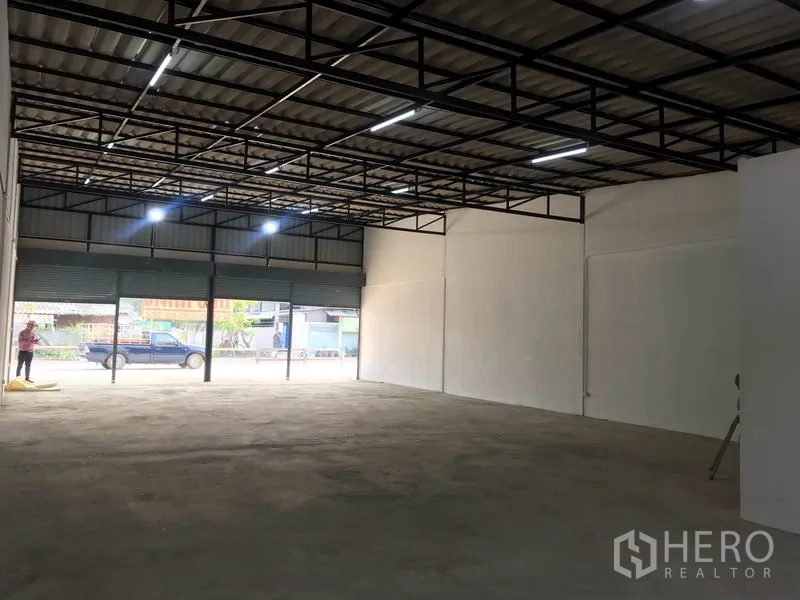 Warehouse for rent in Lam Luk Ka, Pathum Thani - Warehouse interior facing the frontage with three roller shutters and ample natural light.