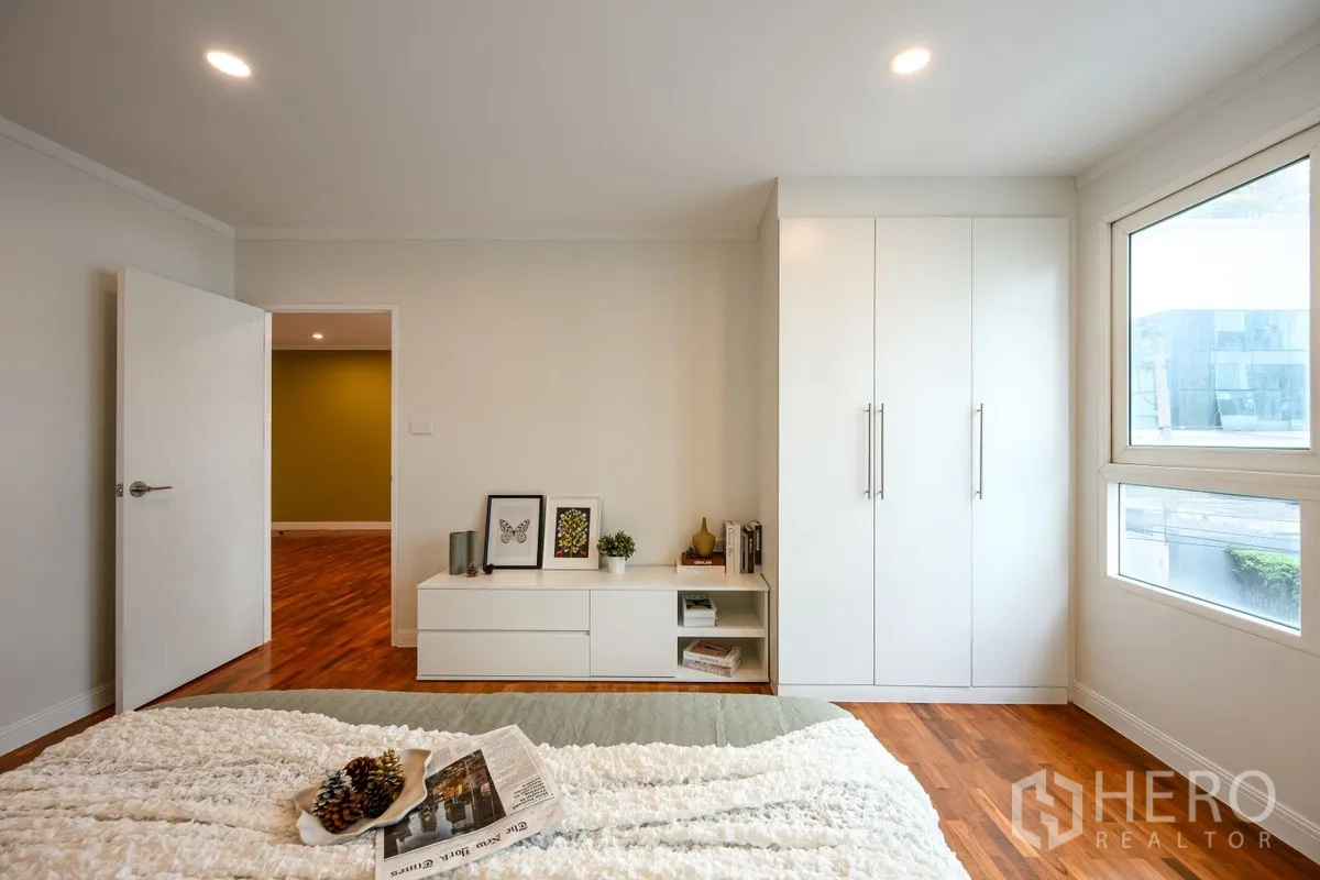 公寓 for sale in Watthana, Bangkok - 卧室收纳区，带内置白色衣柜、矮柜与转角窗。