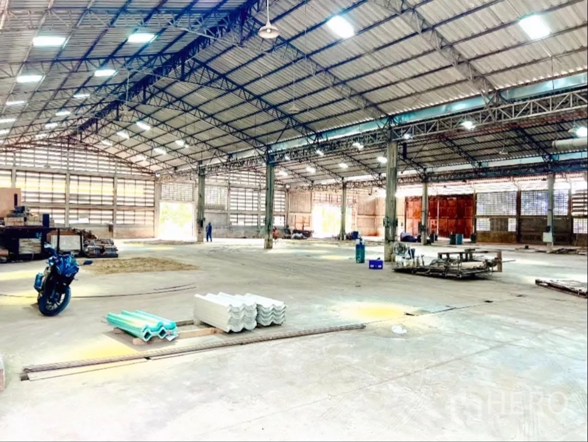 Factory for rent in Sai Noi, Nonthaburi - Clear-span factory interior with wide bays and roller doors at the far end.