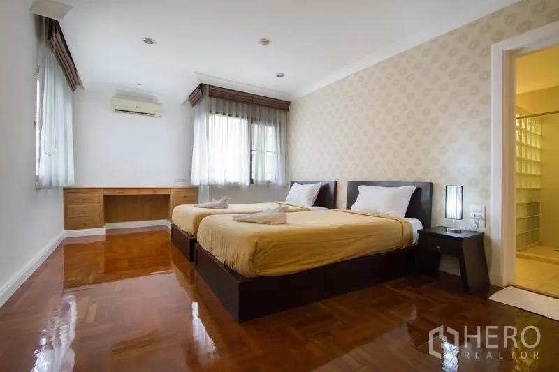 公寓 出租在Watthana, Bangkok - 次卧配双床，内置书桌与大窗户，带套内卫浴入口。