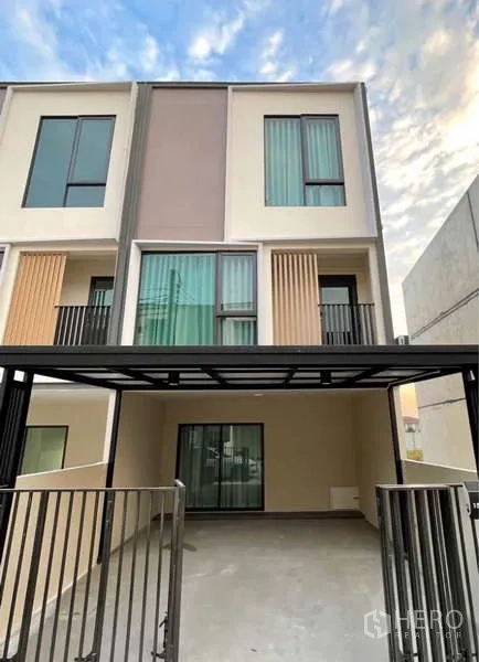 Townhouse for rent in Bang Phli, Samut Prakan - Modern townhouse exterior with covered carport and tall windows.