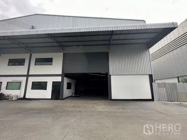 货栈 出租在Samut Prakan - 北榄府邦普里仓库外观，带宽大雨棚装卸区与卷帘门。