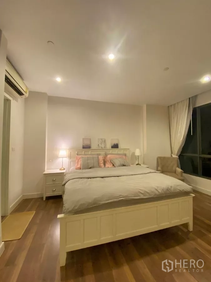 Condominium for rent in Phra Khanong, Bangkok - Master bedroom with king bed, bedside tables, and wood floors.