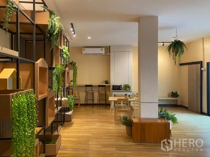 Retail Space for rent in Khlong Toei, Bangkok - Retail space with decorative display shelving and greenery, counter with stools, and warm wood floors.