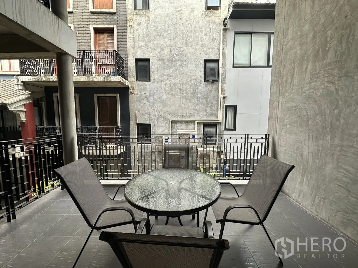 公寓 for rent in Pathum Wan, Bangkok - 带顶露台配圆形玻璃桌与椅子，面向周边建筑外立面。