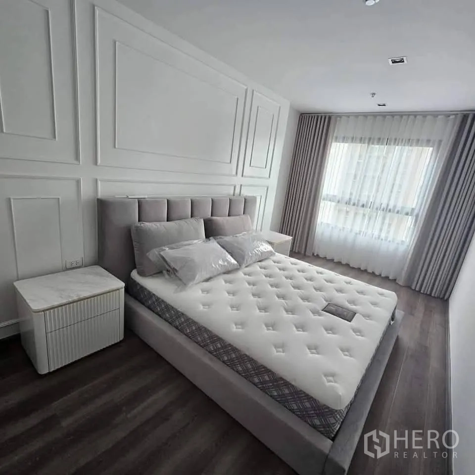 คอนโด for rent in Huai Khwang, Bangkok - อีกมุมของห้องนอนที่มีหน้าต่างบานกว้างและผ้าม่านสีเทาอ่อน