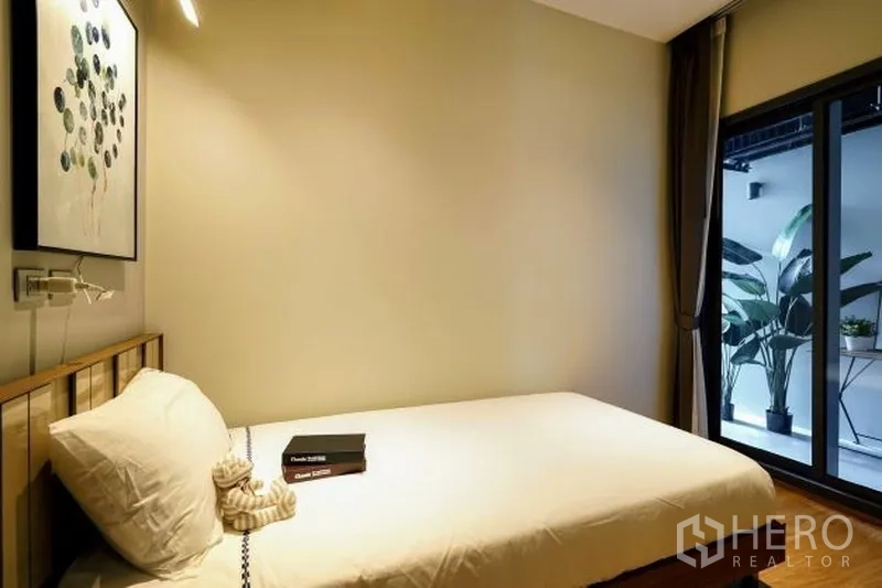 公寓 出租在Watthana, Bangkok - 第三卧室紧凑，单人床，推拉门通向摆放绿植的阳台。