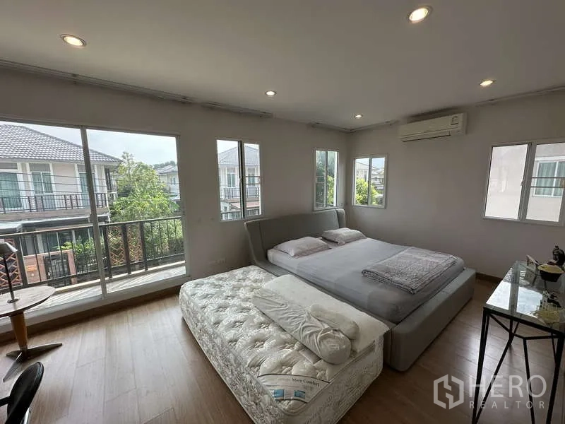 Detached House for sale in Sai Mai, Bangkok - Spacious master bedroom with corner windows and balcony access.