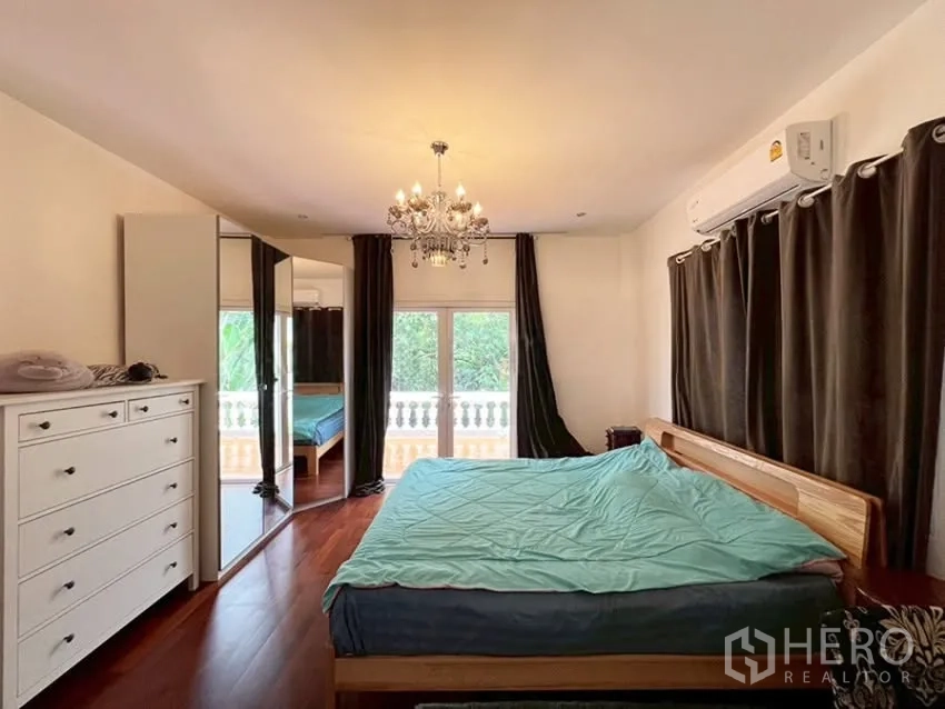Detached House for rent in Phra Khanong, Bangkok - Primary bedroom with chandelier, curtains, and balcony access.