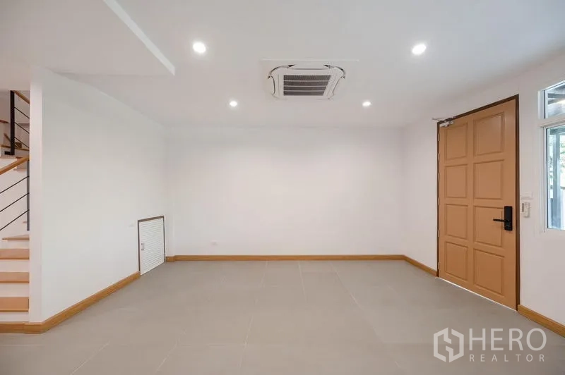 联排别墅 出售在Lat Phrao, Bangkok - 入口客厅，木质入户门与吊顶空调。