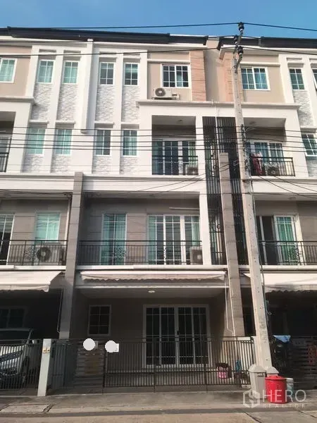Home Office for rent in Bang Na, Bangkok - Modern multi-storey home office facade in Bang Na with balconies, sliding glass doors, gated carport, and overhead cables.