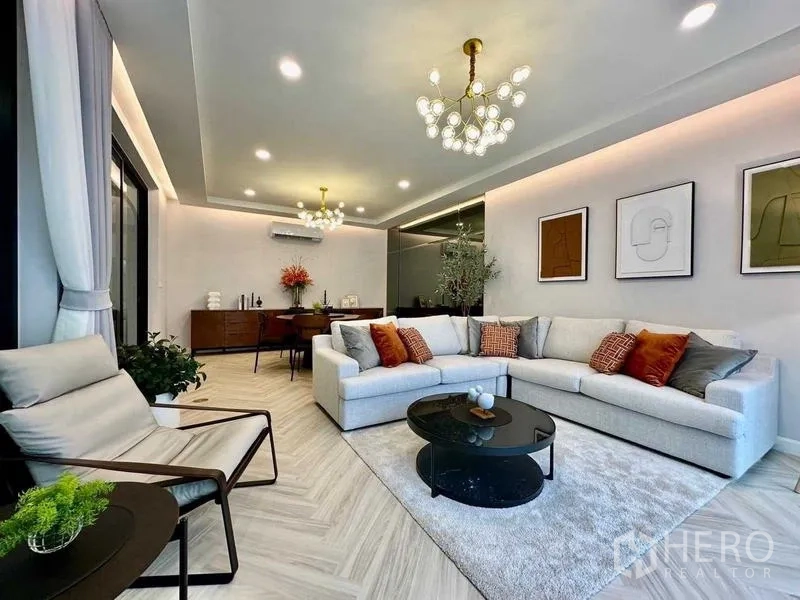 独立式住宅 出租在Bang Phli, Samut Prakan - 时尚会客区，枝形吊灯、组合沙发与墙面装饰画。