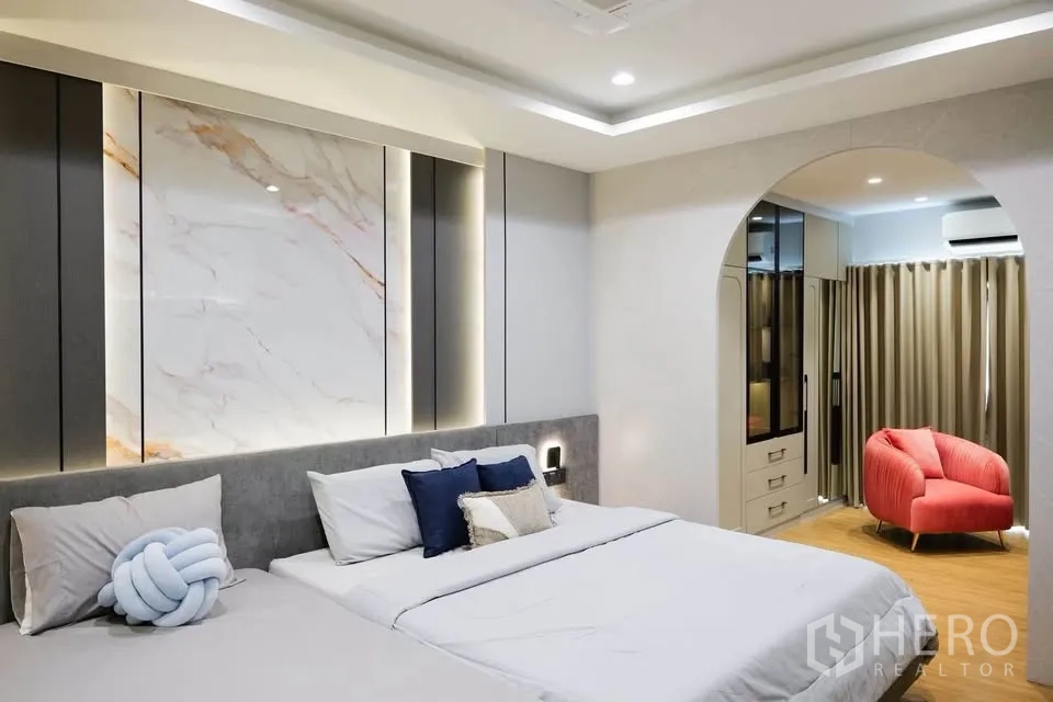 บ้านเดี่ยว for sale in Bang Phli, Samut Prakan - ห้องนอนหลักกว้าง เตียงคู่ และทางเดินโค้งสู่โซนแต่งตัว.
