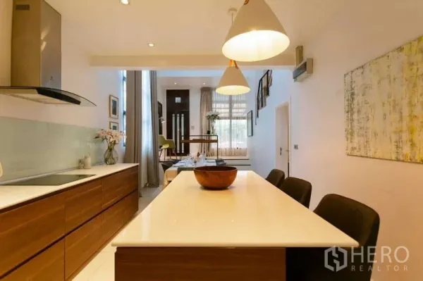 Home Office for sale in Watthana, Bangkok - Open kitchen with island, pendant lights and view toward the dining and entry area.