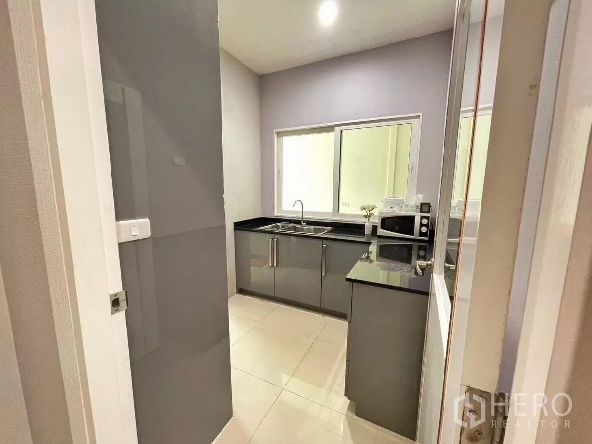 Detached House for rent in Bang Khen, Bangkok - Separate Thai kitchen with double sink, countertops and window ventilation.